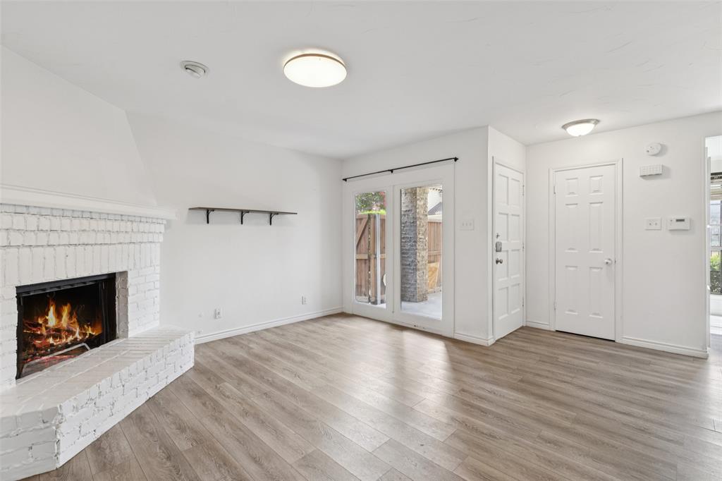 5200 Martel Avenue, Unit 36A Dallas, TX 75206 - Photo 6 of 34 a view of an empty room with wooden floor fireplace and a window