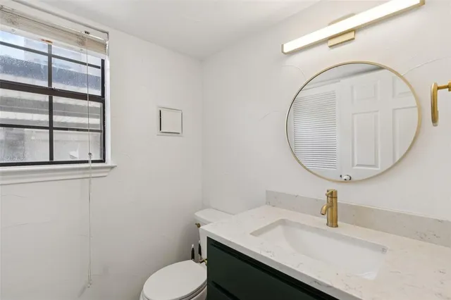 a bathroom with a sink toilet and a mirror