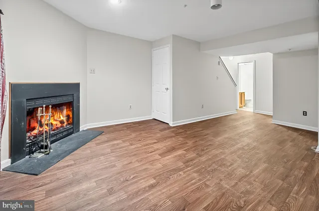 a view of a livingroom with wooden floor a fireplace and window