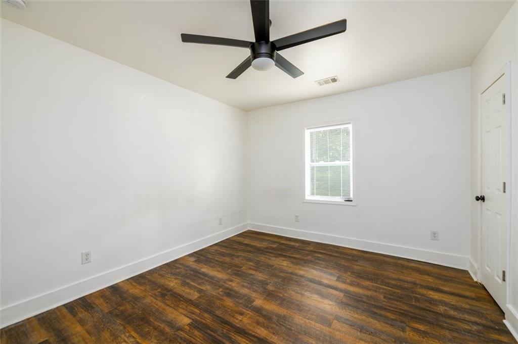 1285 Avon Avenue Southwest Atlanta, GA 30310 - Photo 18 of 28 a view of a room with wooden floor and a ceiling fan