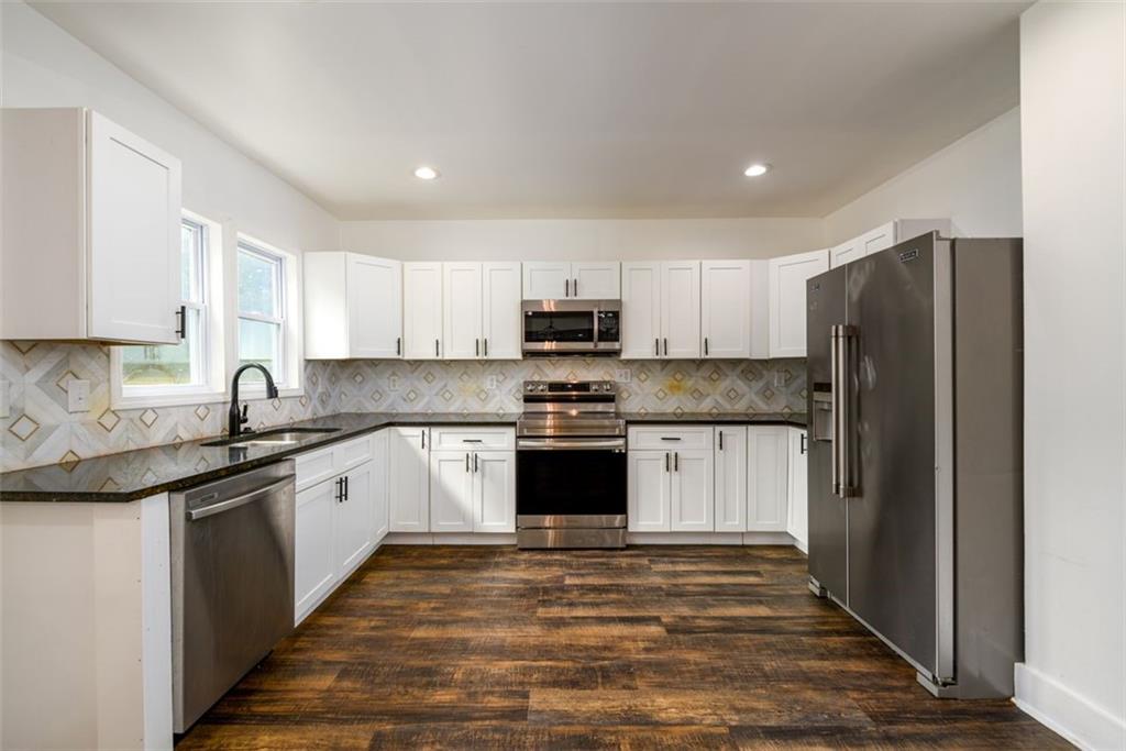 1285 Avon Avenue Southwest Atlanta, GA 30310 - Photo 8 of 28 a kitchen with granite countertop white cabinets and stainless steel appliances