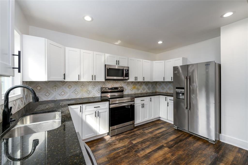1285 Avon Avenue Southwest Atlanta, GA 30310 - Photo 9 of 28 a kitchen with stainless steel appliances granite countertop a stove top oven a sink and a refrigerator