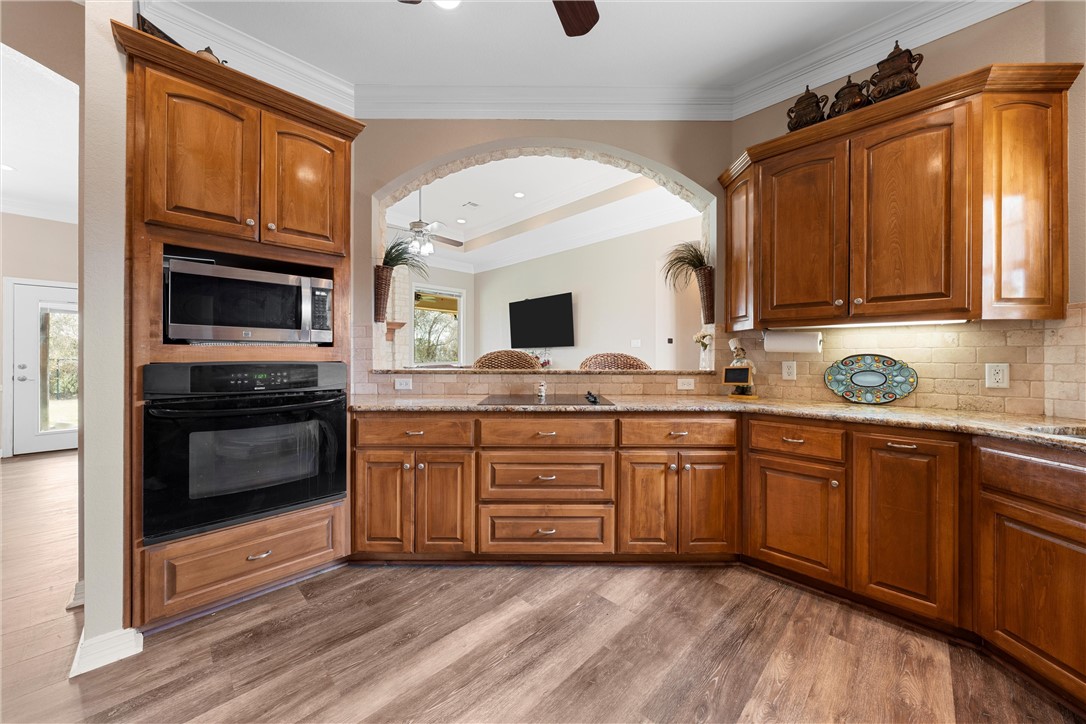 10513 T Bury Lane Waco, TX 76708 - Photo 15 of 36 a kitchen with granite countertop a stove a sink and a microwave