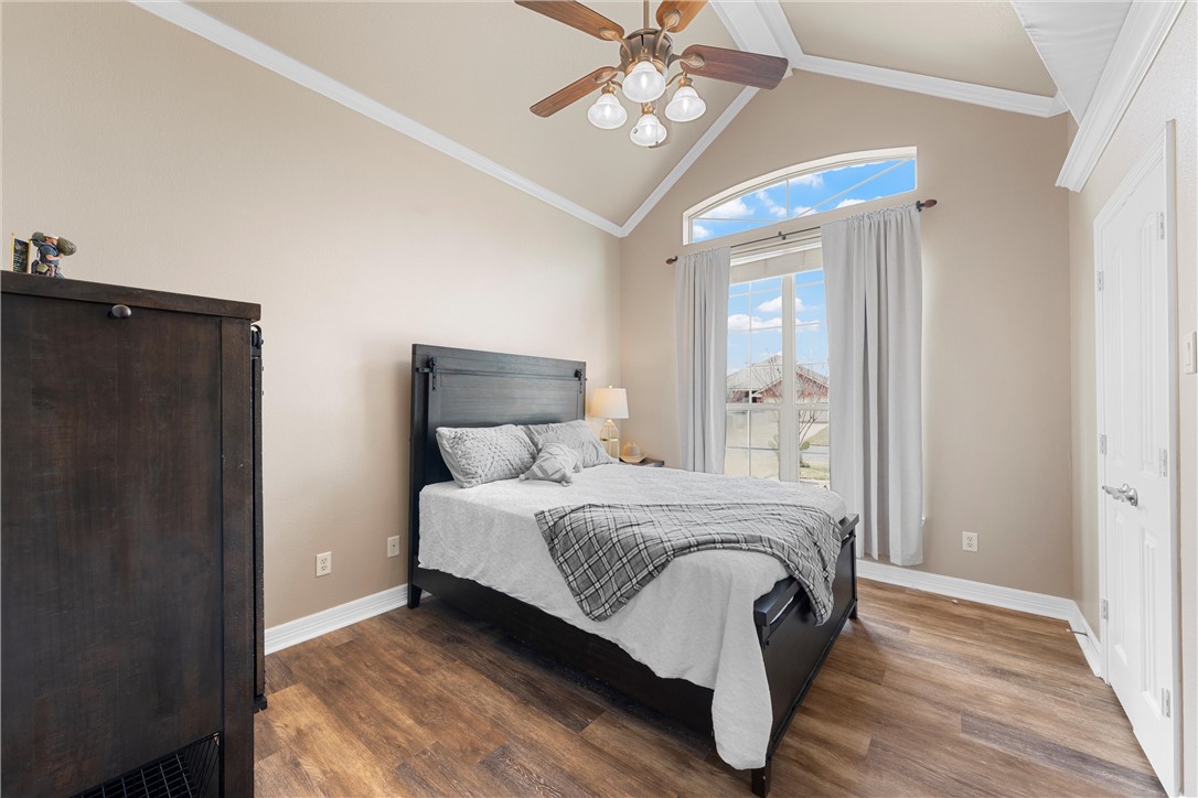 10513 T Bury Lane Waco, TX 76708 - Photo 23 of 36 a bedroom with a bed and a chandelier