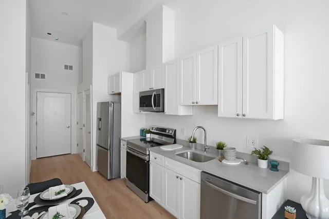 a kitchen with cabinets appliances and a counter space