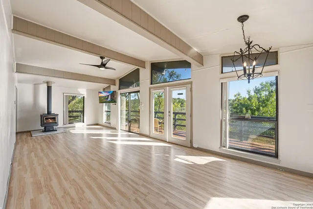 a view of empty room with wooden floor and floor to ceiling window