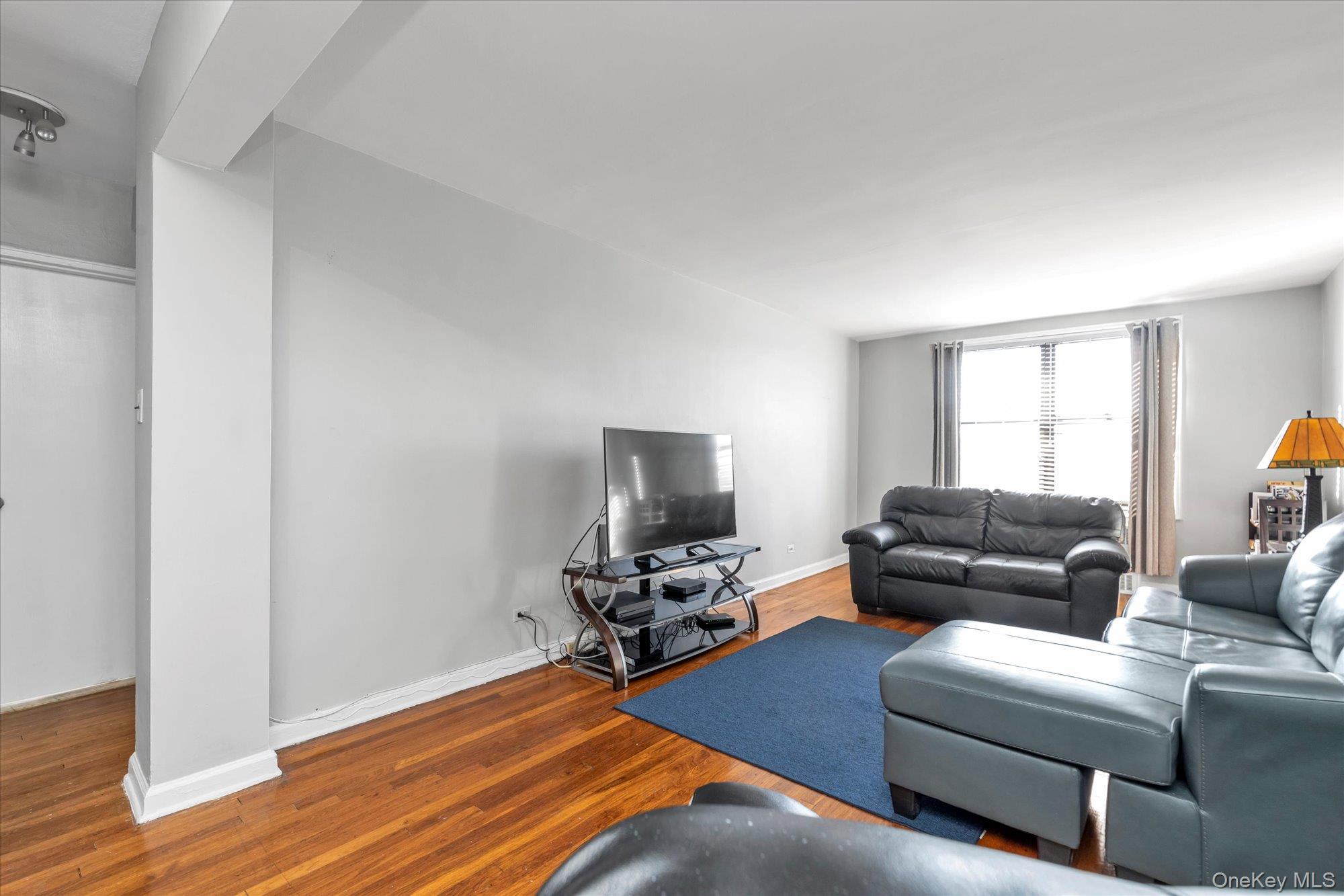 83-40 Austin Street, Unit 7K Queens, NY 11415 - Photo 4 of 19 a living room with furniture and a flat screen tv
