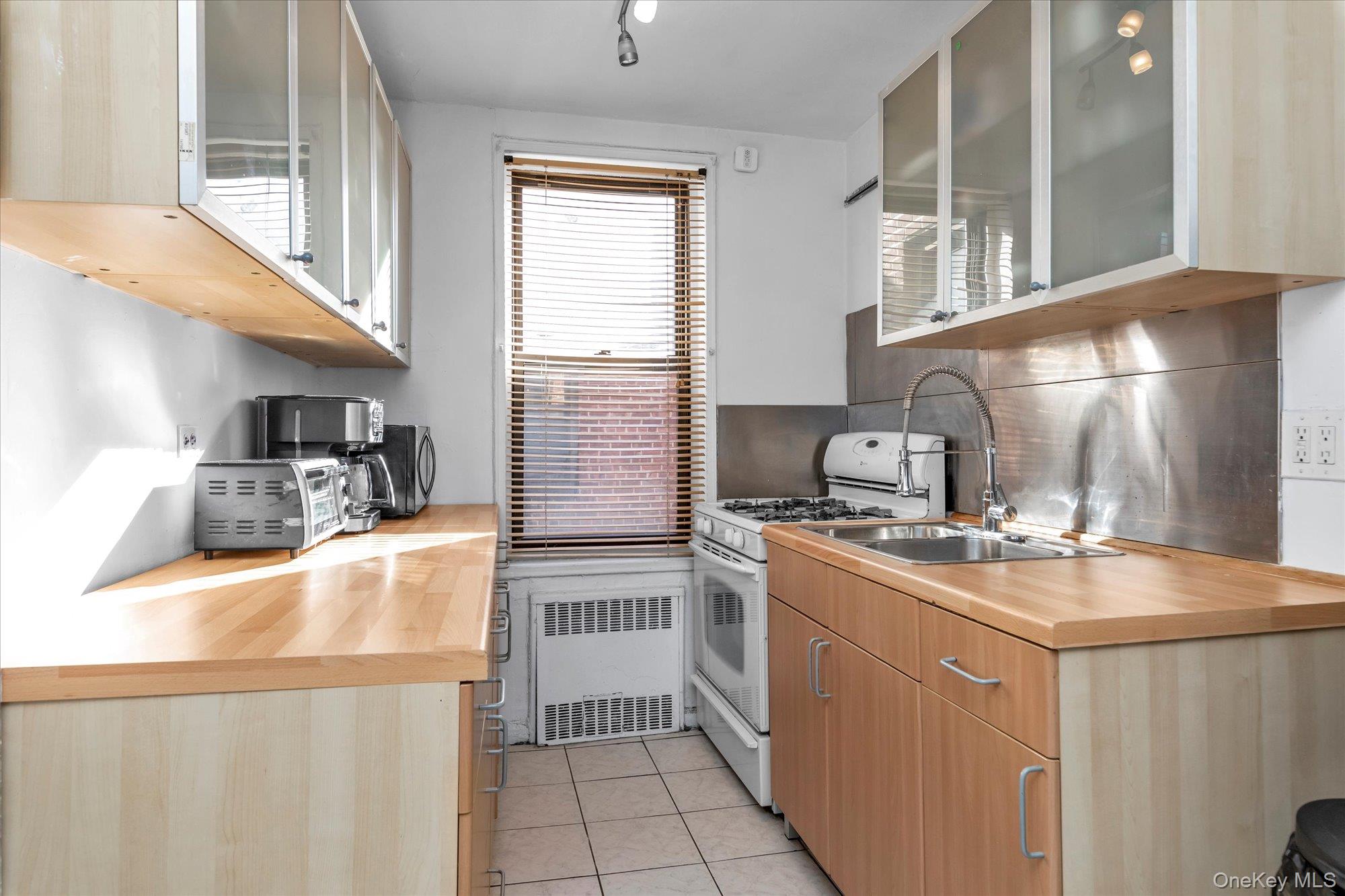 83-40 Austin Street, Unit 7K Queens, NY 11415 - Photo 7 of 19 a kitchen with stainless steel appliances granite countertop a sink stove and refrigerator