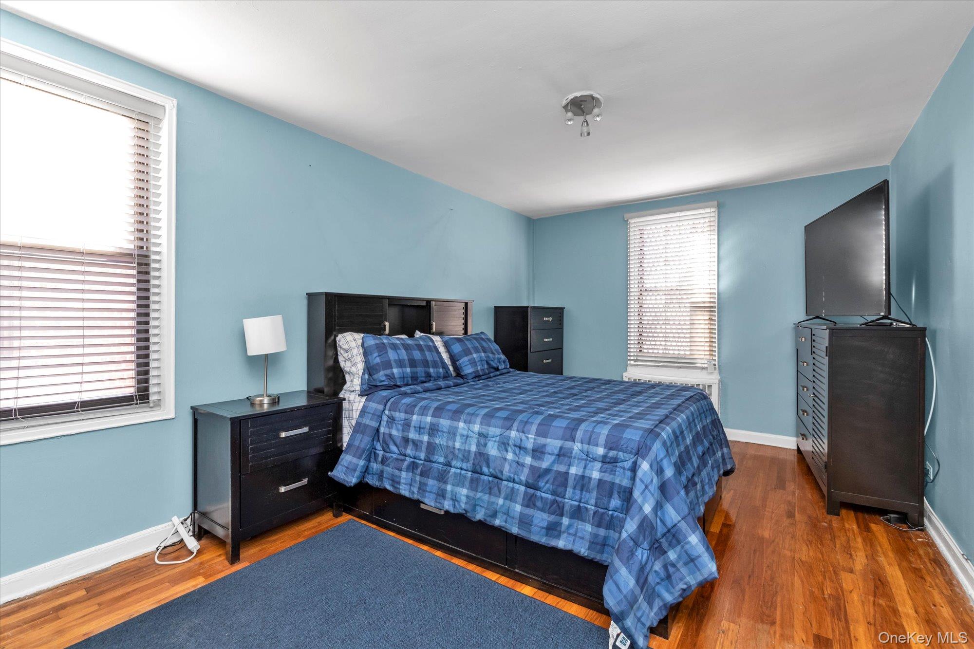 83-40 Austin Street, Unit 7K Queens, NY 11415 - Photo 10 of 19 a bedroom with a bed and tv
