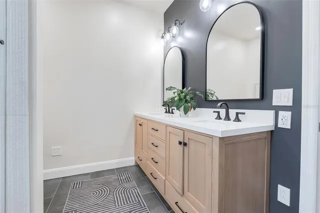 a spacious bathroom with a double vanity sink and a mirror