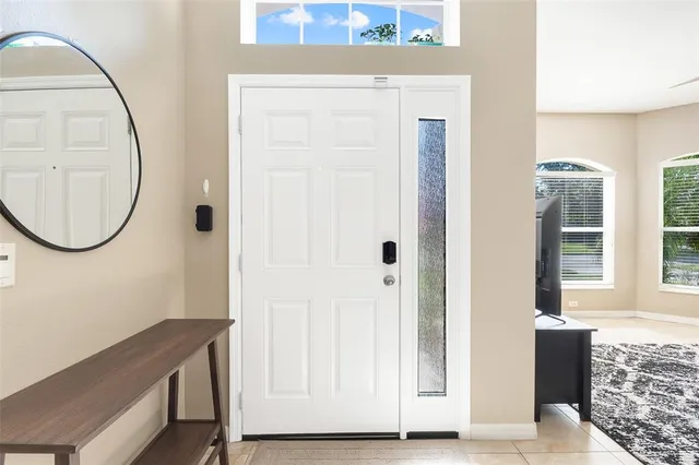 an entryway view with wooden floor mirror and a window