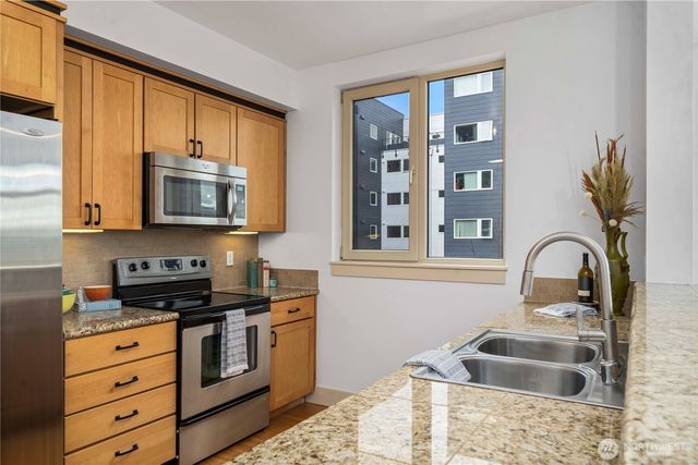 a kitchen with granite countertop kitchen island and stainless steel appliances