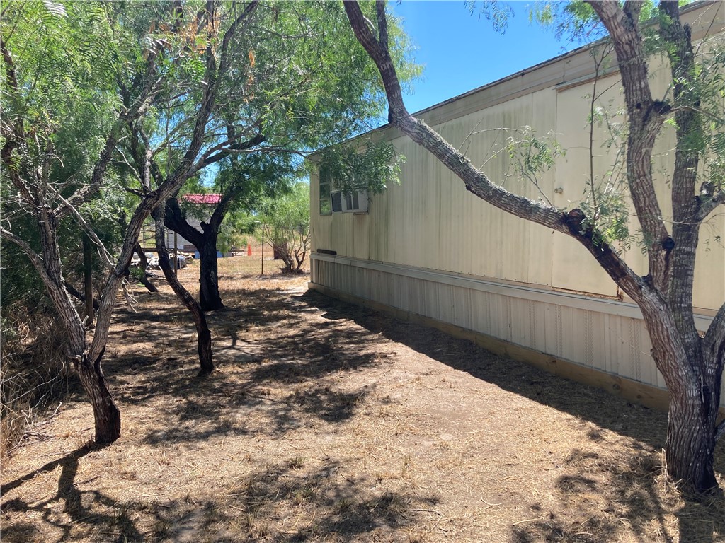 1134 East County Road 2328 Riviera, TX 78379 - Photo 25 of 27 a backyard of a house with large trees and wooden fence