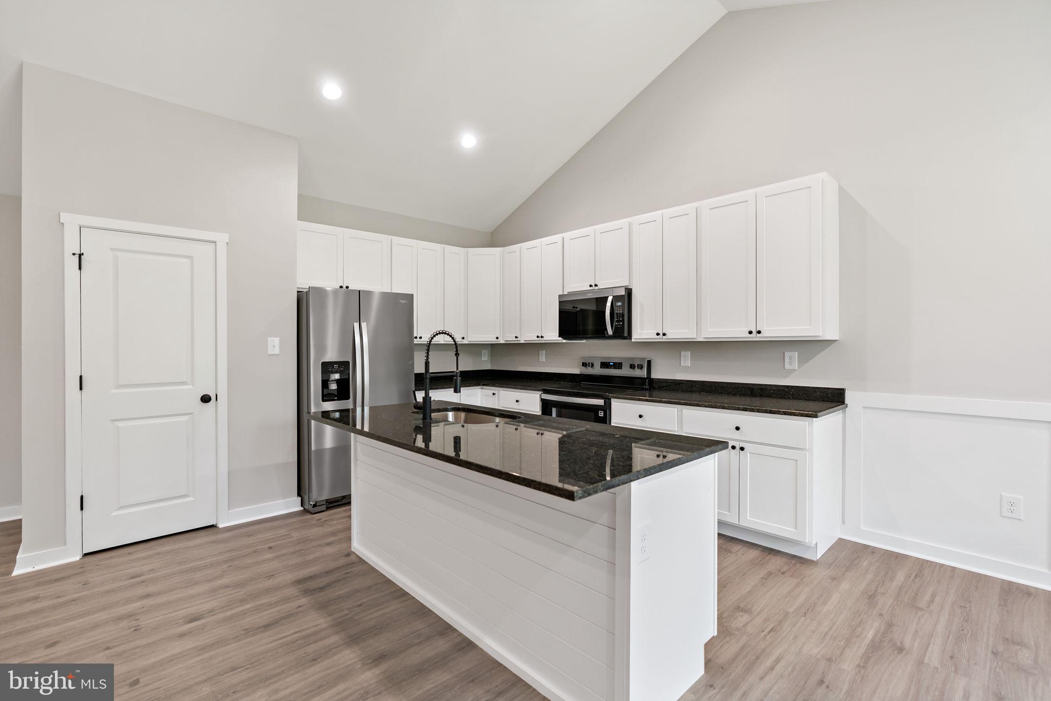 39 Mdg Berkeley Springs Berkeley Springs, WV 25411 - Photo 14 of 46 a kitchen with stainless steel appliances granite countertop a refrigerator a stove a sink and white cabinets with wooden floor