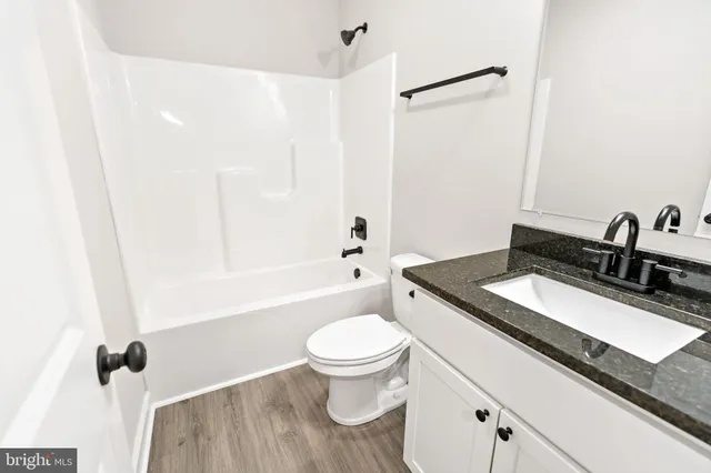 a bathroom with a granite countertop sink a toilet and a mirror
