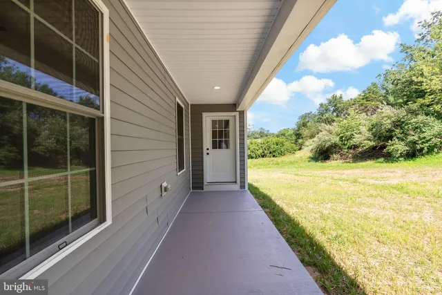 a front view of house with yard and trees in the background