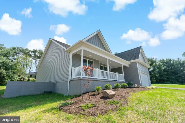 a view of a house with wooden deck front of house