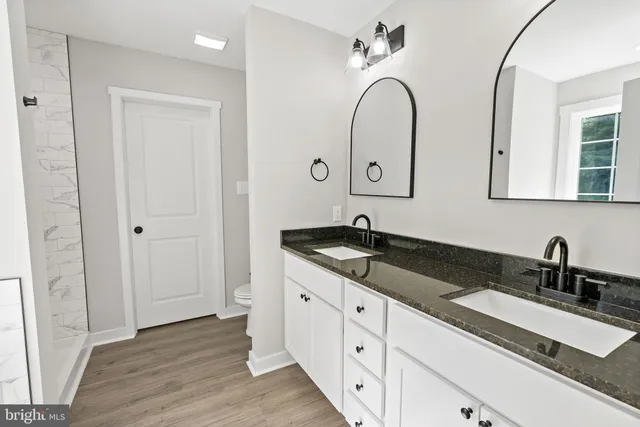 a bathroom with a double vanity sink and a mirror