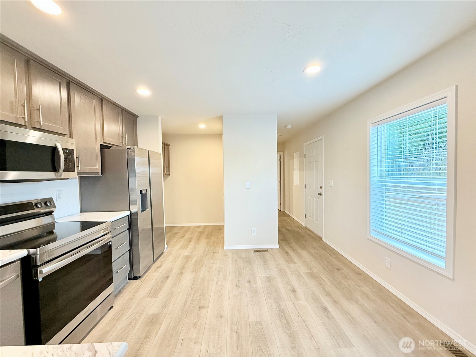 2322 Tacoma Road East, Unit 11 Puyallup, WA 98371 - Photo 4 of 15 a view of a kitchen center island wooden floor and stainless steel appliances