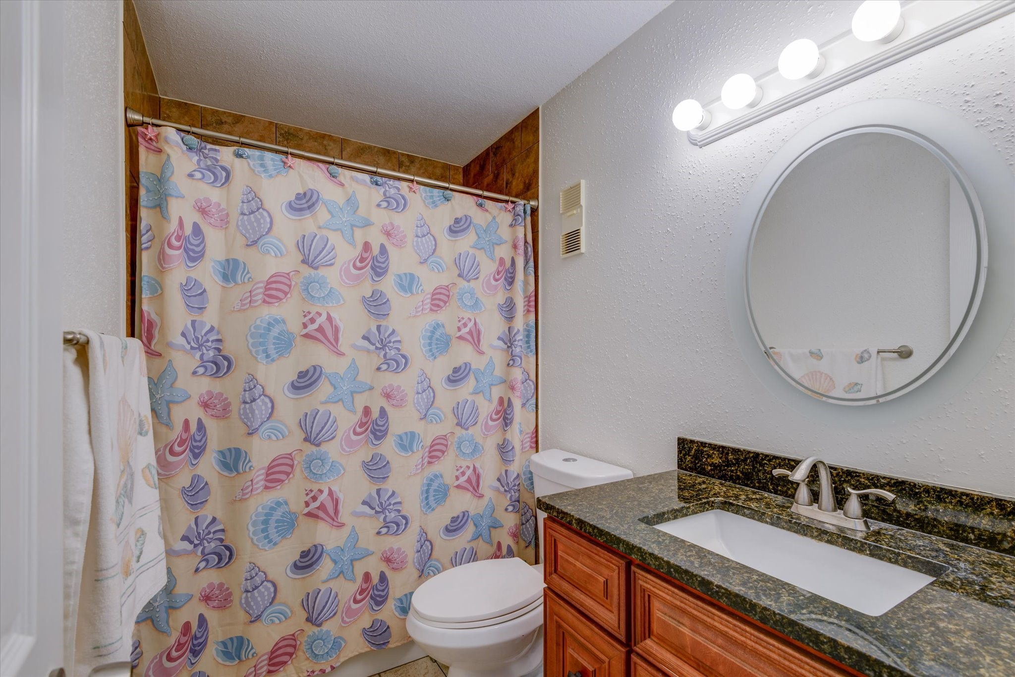 4001 East NASA Parkway, Unit 222 El Lago, TX 77586 - Photo 14 of 30 a bathroom with a granite countertop sink toilet a mirror and shower curtain