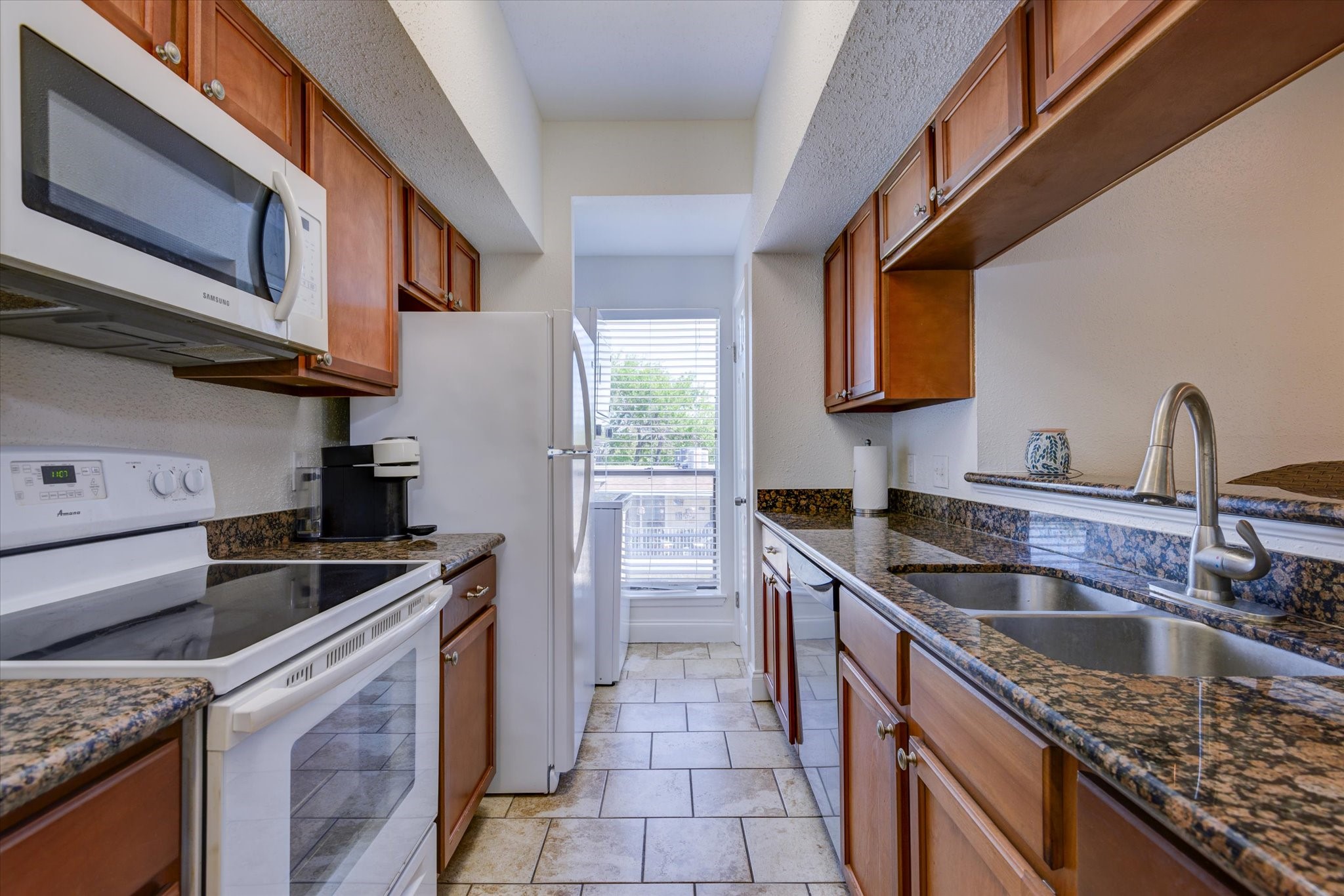 4001 East NASA Parkway, Unit 222 El Lago, TX 77586 - Photo 6 of 30 a kitchen with stainless steel appliances granite countertop a sink stove and refrigerator