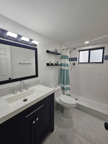 a bathroom with a double vanity sink toilet and a mirror