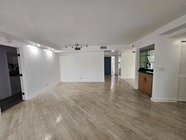 a view of empty room with wooden floor