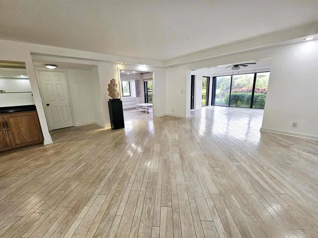 a view of a living room hardwood floor and a kitchen