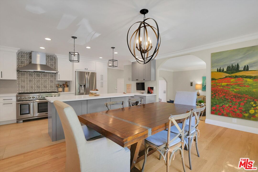a dining room with furniture a kitchen and chandelier
