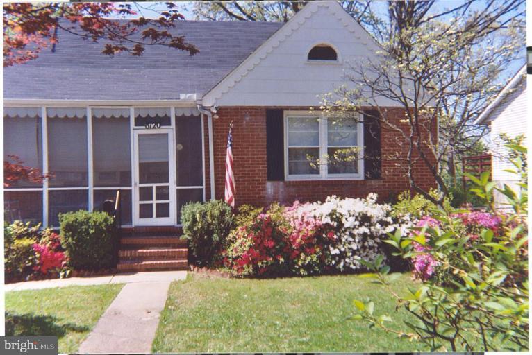 a front view of a house with a yard and fountain in middle