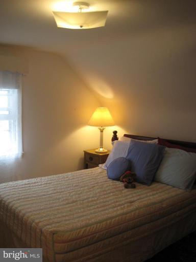 8120 Hillendale Road Parkville, MD 21234 - Photo 13 of 16 a bed sitting in a bedroom with a lamp