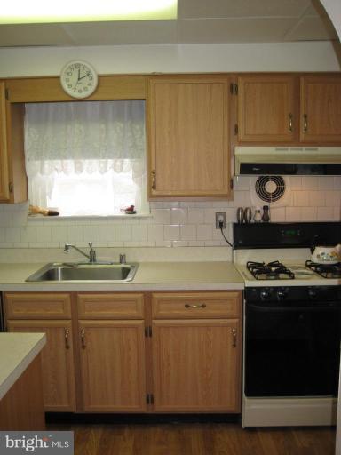 8120 Hillendale Road Parkville, MD 21234 - Photo 6 of 16 a kitchen with a sink a stove and cabinets