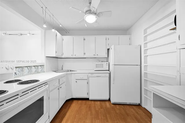 a kitchen with white cabinets and white appliances