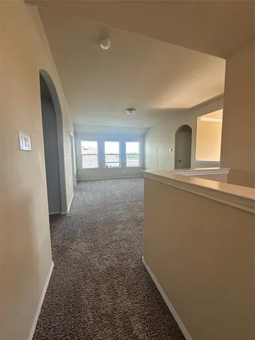 a view of hallway with window and hardwood floor