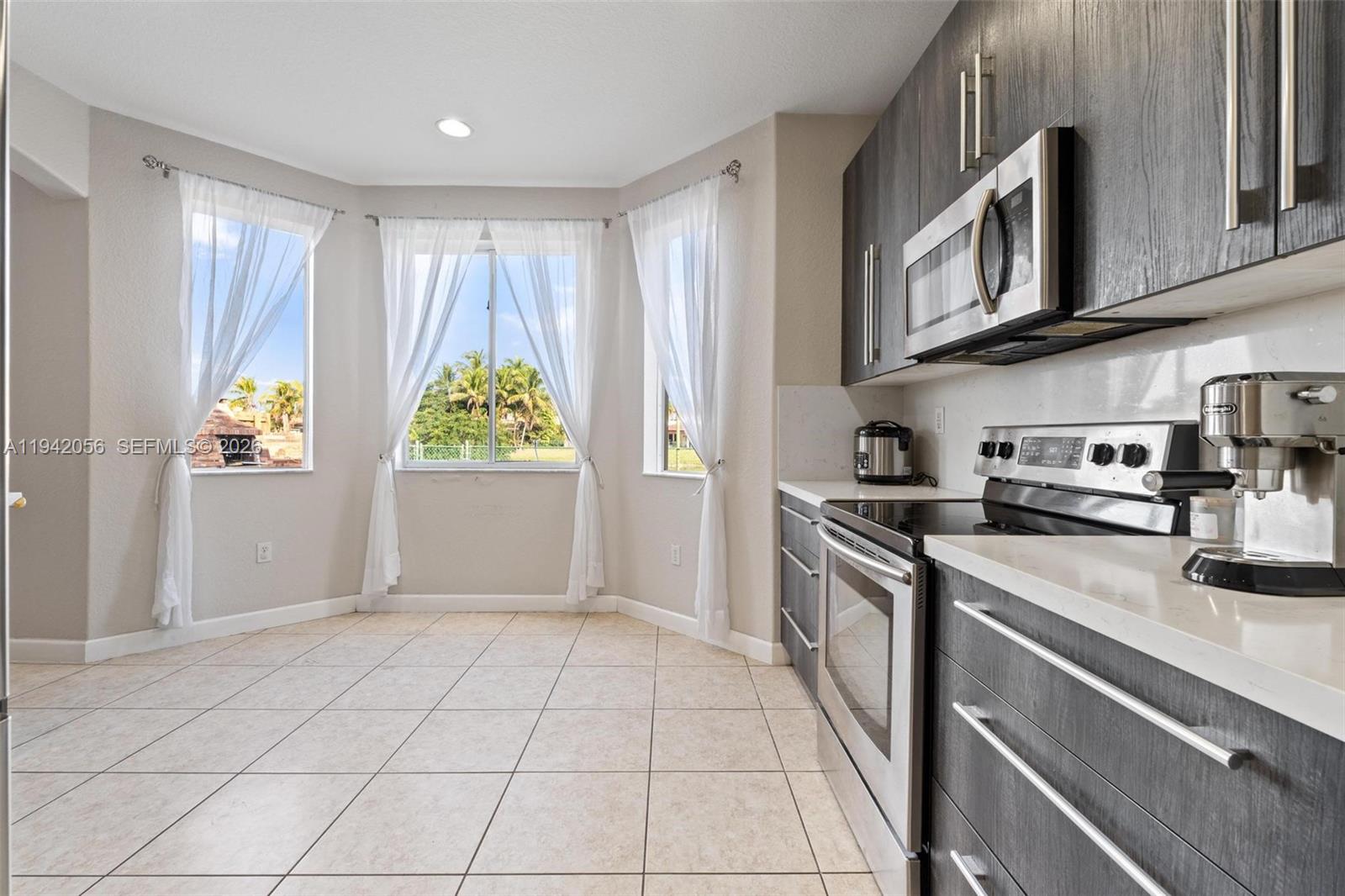 16301 Southwest 70th Street Miami, FL 33193 - Photo 11 of 56 a kitchen with stainless steel appliances granite countertop a refrigerator and a stove top oven