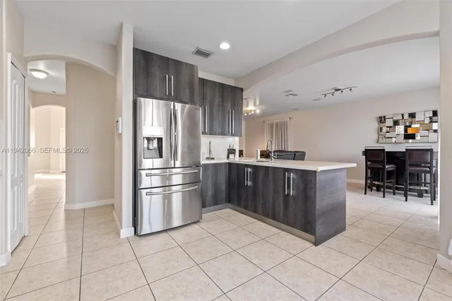 a kitchen with granite countertop a refrigerator and a stove top oven