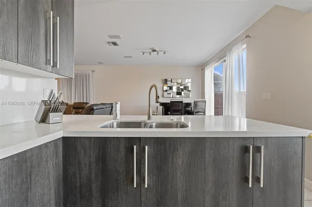 a kitchen with kitchen island a sink a counter space and cabinets