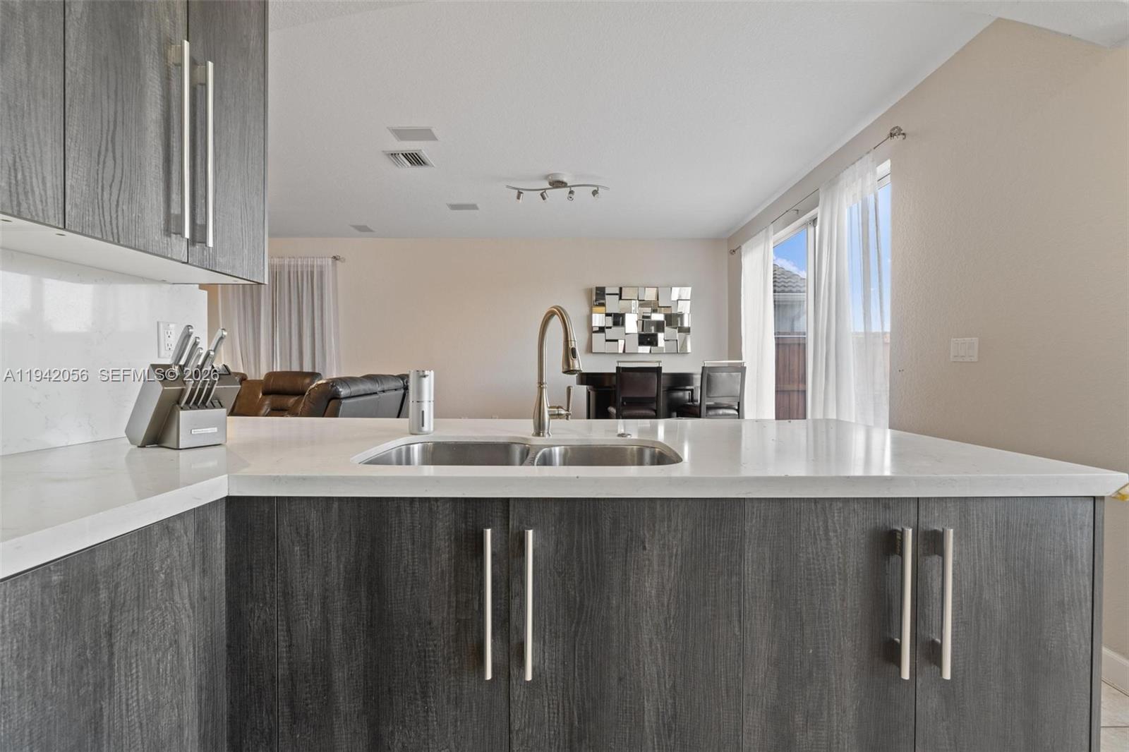 16301 Southwest 70th Street Miami, FL 33193 - Photo 15 of 56 a kitchen with kitchen island a sink a counter space and cabinets