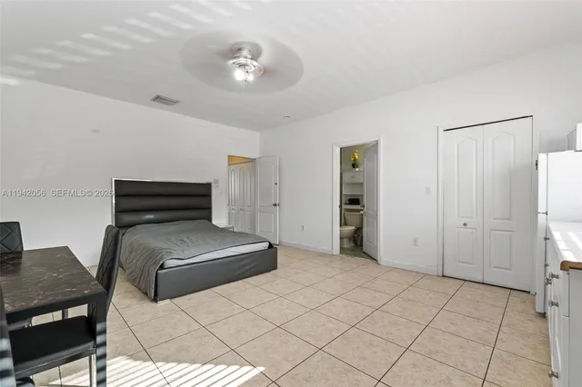 a view of an empty room with closet and a bathroom