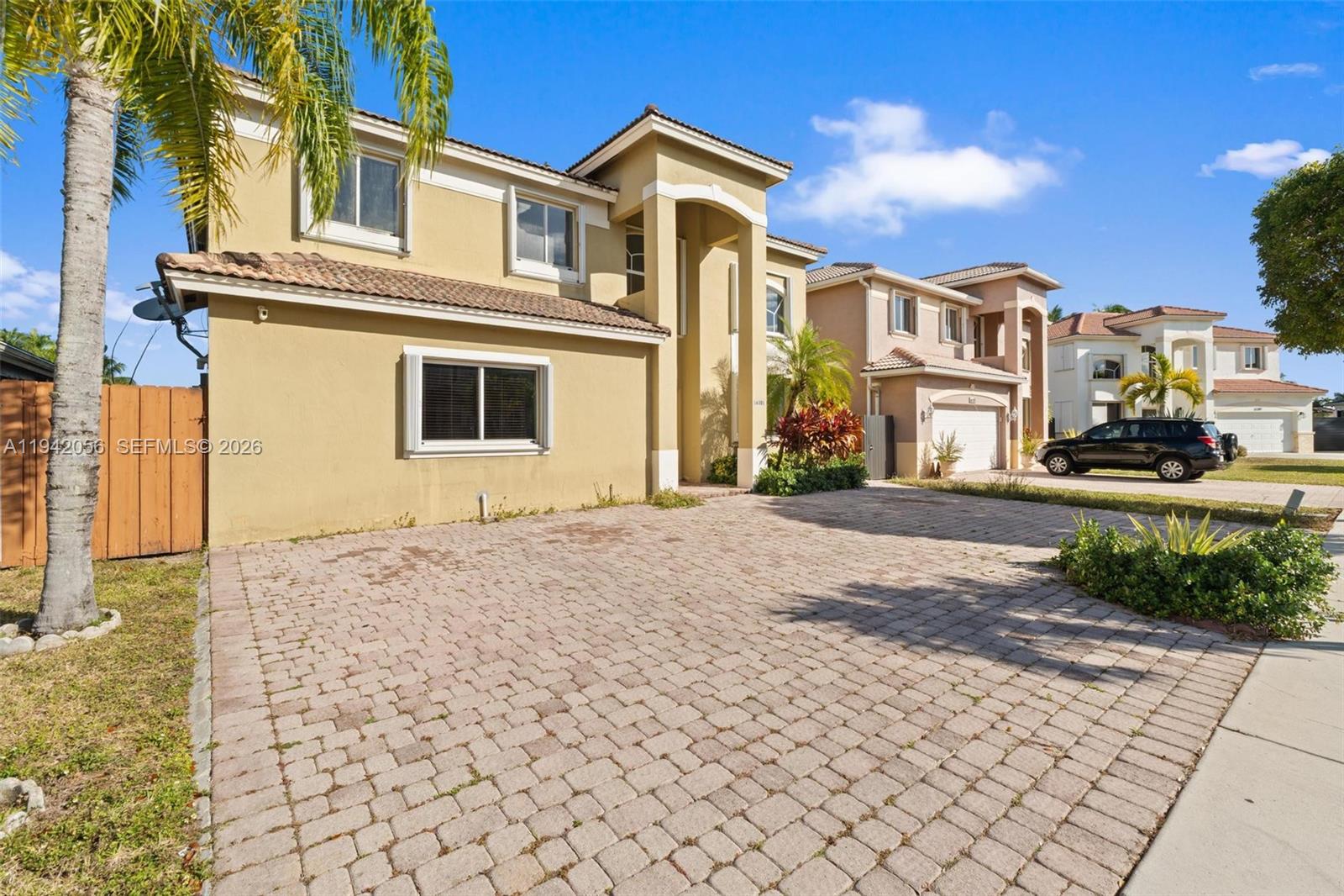 16301 Southwest 70th Street Miami, FL 33193 - Photo 3 of 56 a front view of a house with a yard