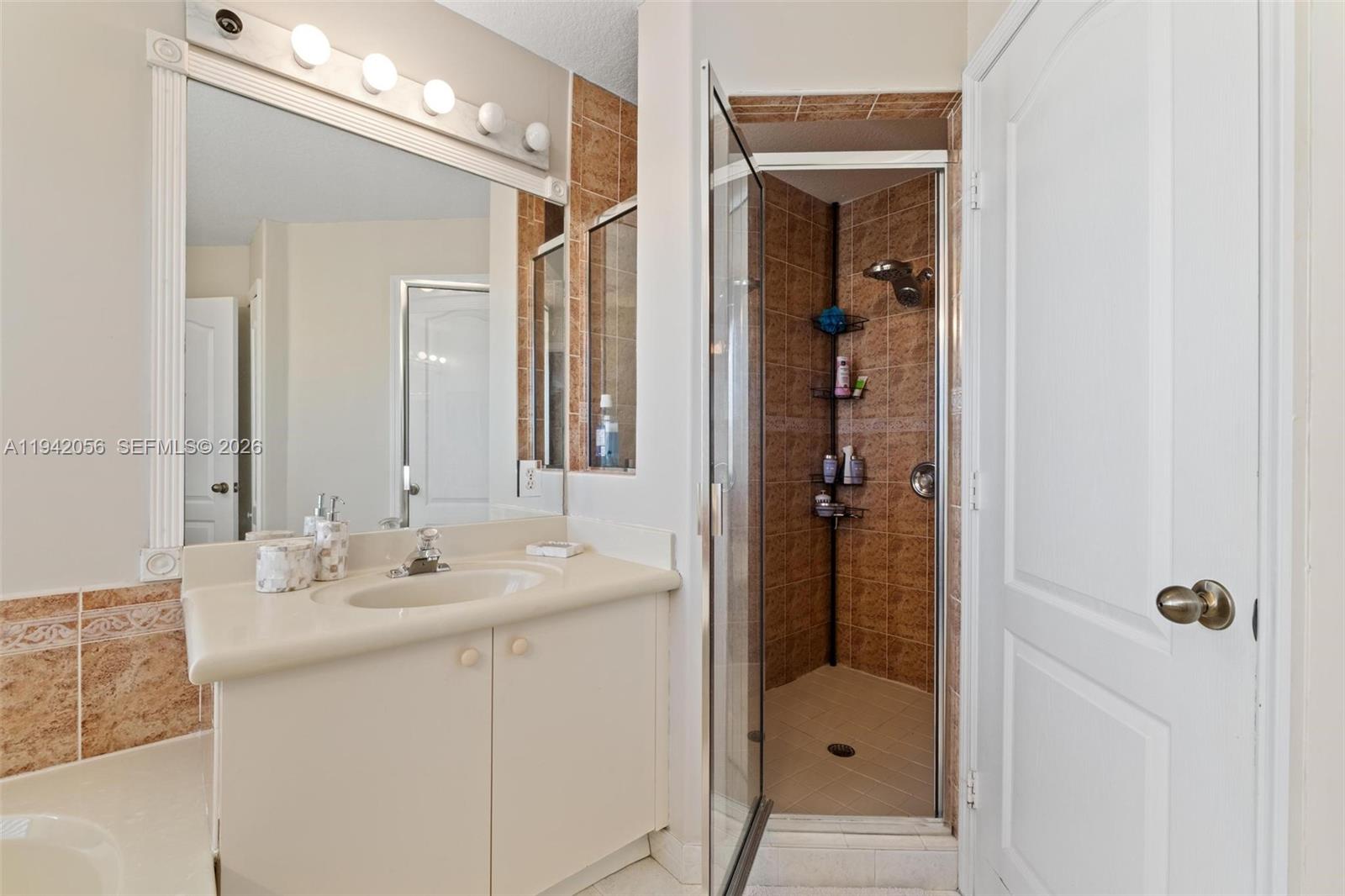 16301 Southwest 70th Street Miami, FL 33193 - Photo 33 of 56 a bathroom with a sink a mirror a vanity and shower