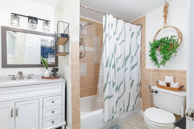 a bathroom with a sink a toilet and a shower curtain