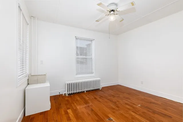 a view of a room with a window and wooden floor
