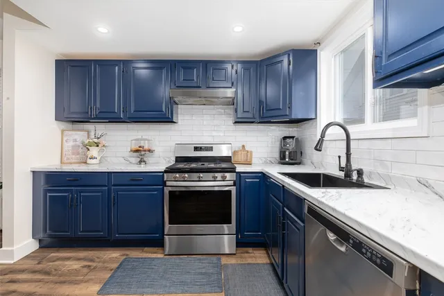 a kitchen with granite countertop wooden cabinets and stainless steel appliances