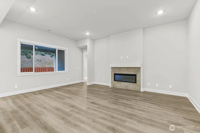 an empty room with wooden floor and a window