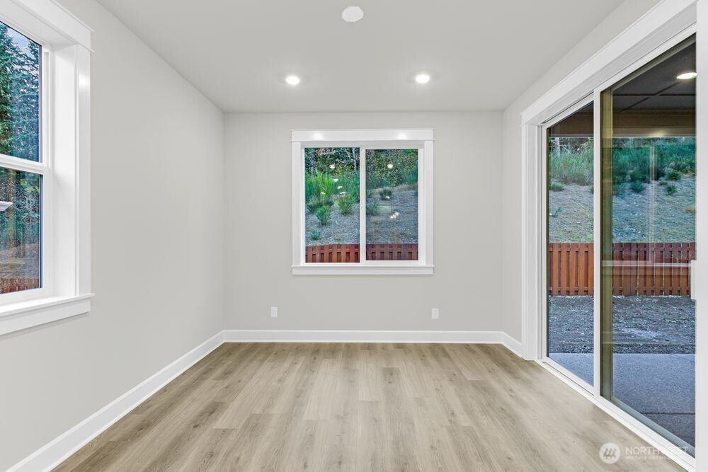 2538 Acer Loop Southeast Lacey, WA 98513 - Photo 7 of 13 an empty room with wooden floor and windows