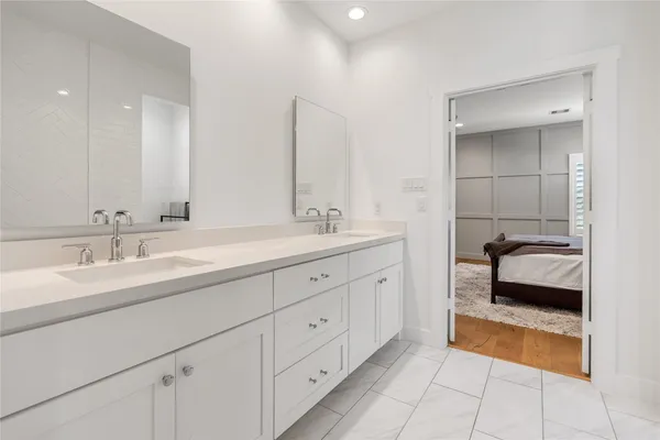 a en suite bathroom with double sink and a large mirror