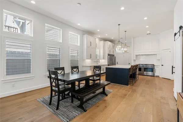 a kitchen with a table chairs sink and cabinets