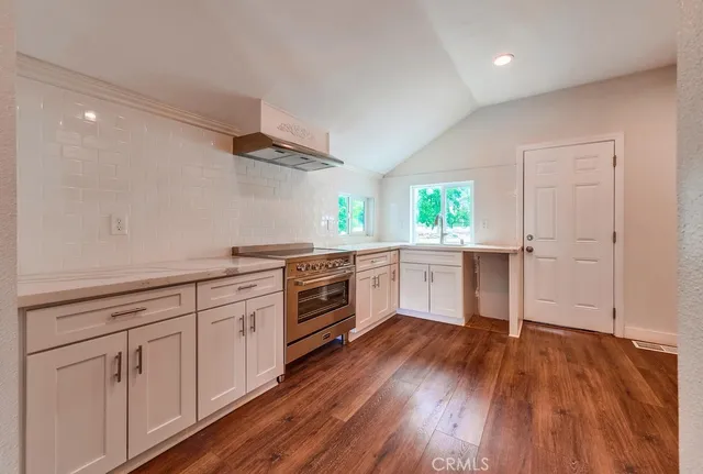 a kitchen with granite countertop white cabinets and white appliances