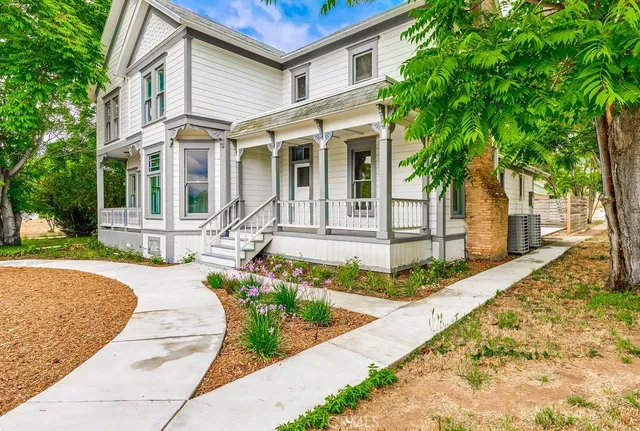 a front view of a house with a garden and plants